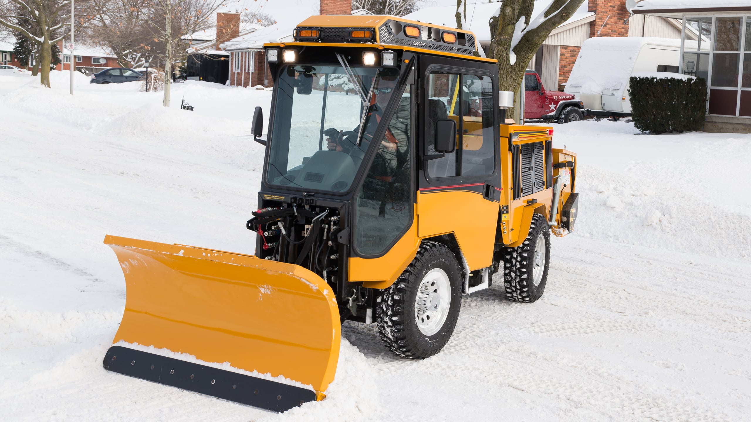 trackless mt7 sidewalk tractor machine with double trip plow attachment plowing snow on sidewalk