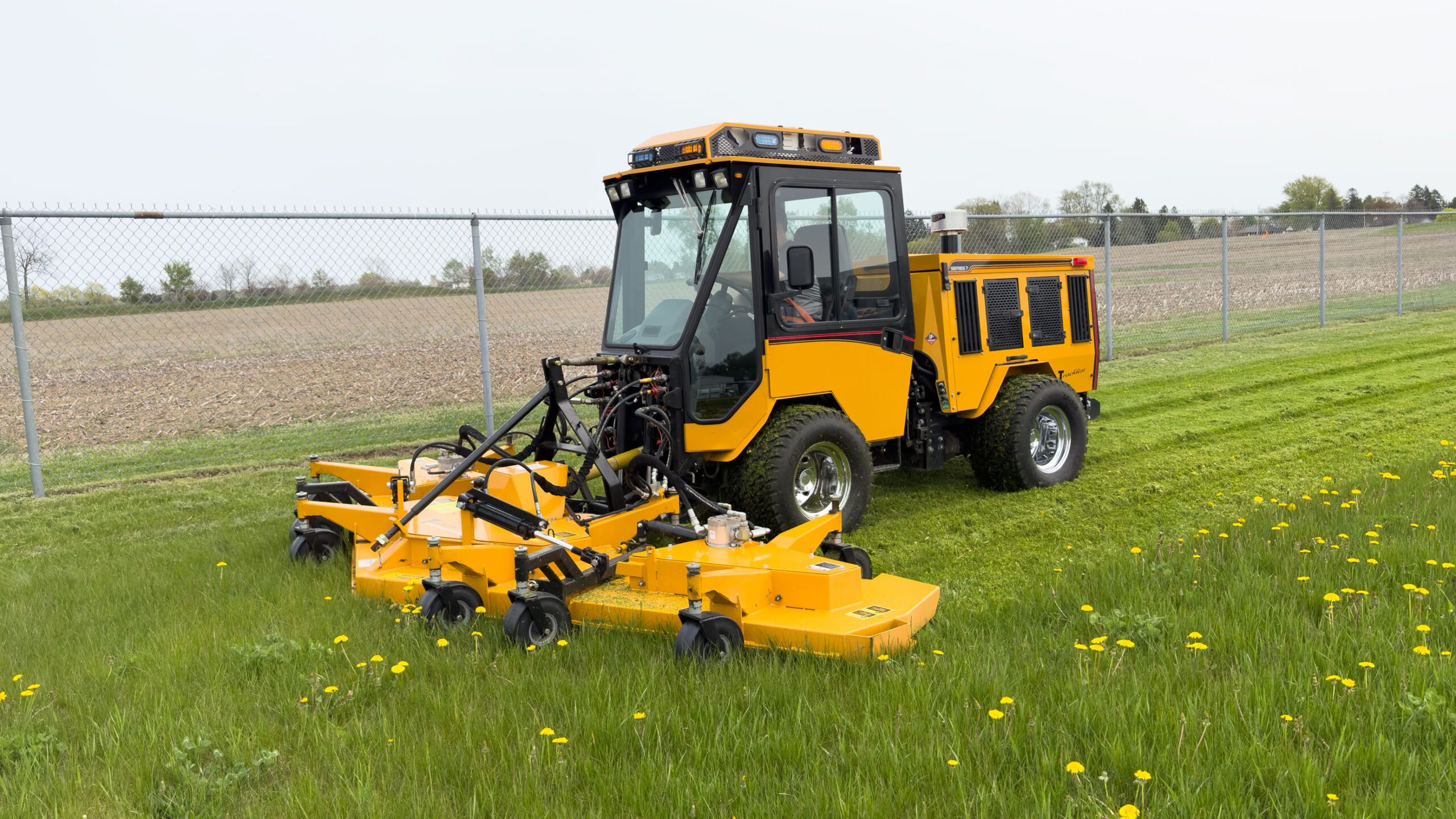 trackless vehicles mt7 tractor machine with rotary mower attachment mowing grass