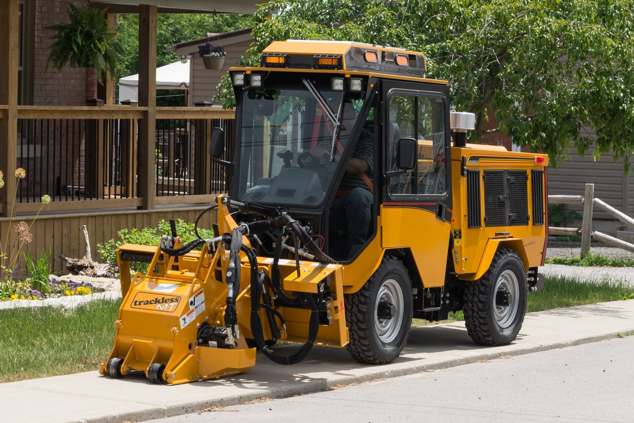 trackless vehicles cold planer attachment on sidewalk tractor side view