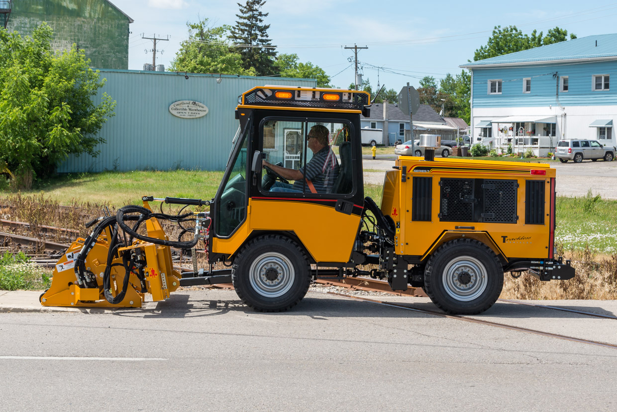 trackless vehicles cold planer attachment on sidewalk tractor side view