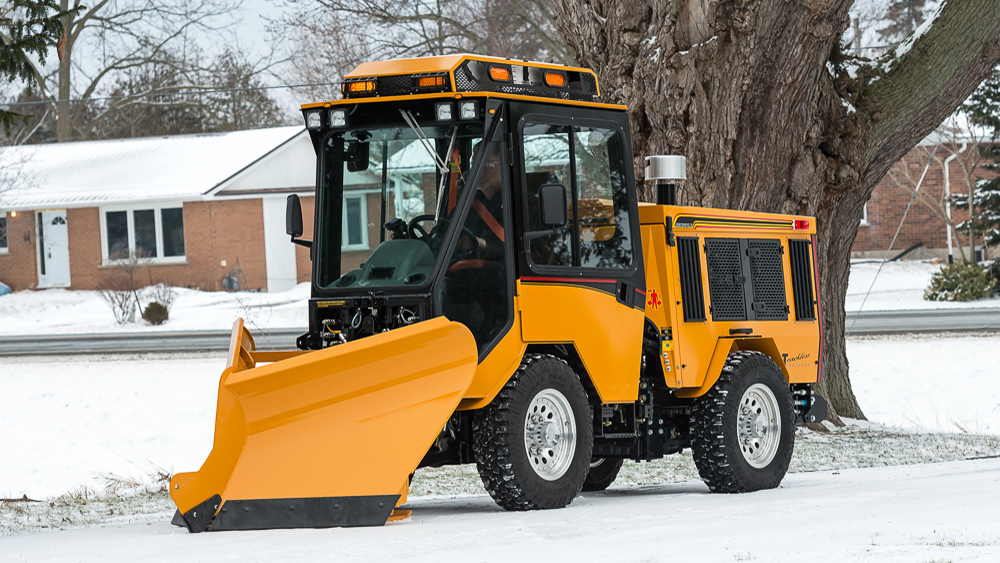trackless vehicles fixed wing v-plow attachment on sidewalk tractor in snow side view