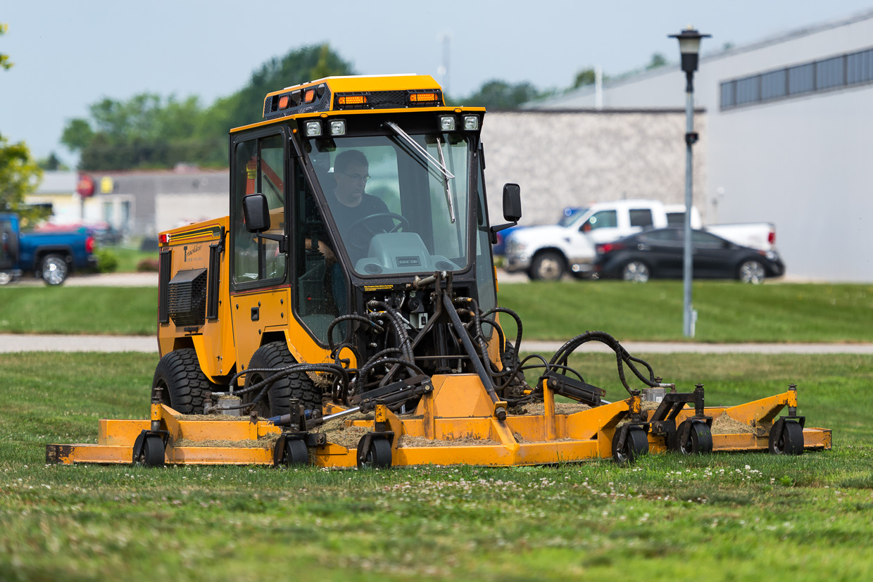 trackless vehicles rotary finishing mower 14' attachment on sidewalk municipal tractor mowing grass front view