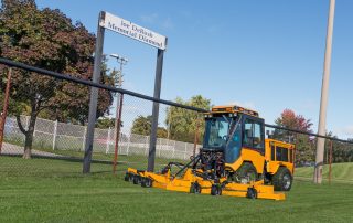 trackless vehicles rotary finishing mower 14' attachment on sidewalk municipal tractor mowing grass front side view
