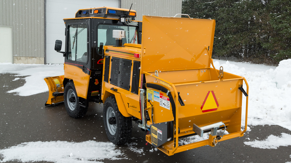 trackless vehicles rear-mount sidewalk spreader attachment on sidewalk tractor in snow rear side view