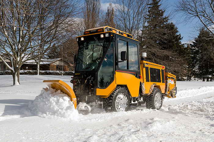 trackless vehicles double trip plow attachment on sidewalk tractor in snow front side view