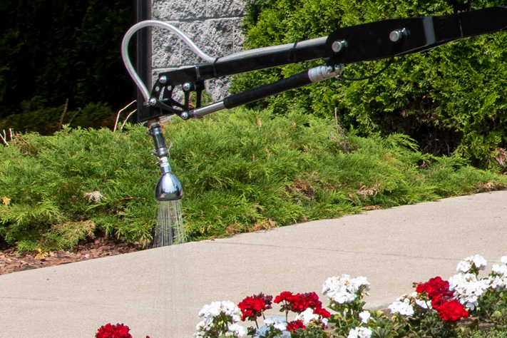 trackless vehicles mt7 machine and spray arm attachment with watering head watering flowers in flower bed